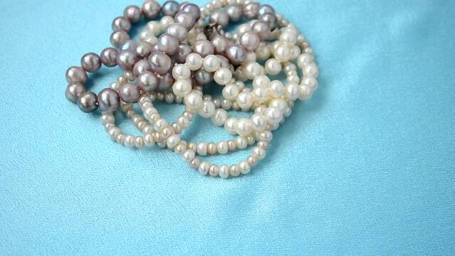 Beads from pearls. Shooting on blue silk