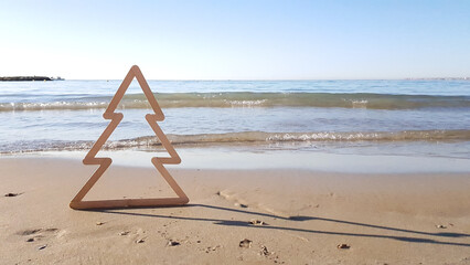Fototapeta na wymiar siluet Christmas tree on the beach on the background of the sea in Spain