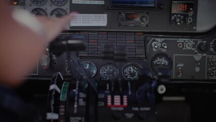 Female pilot touching controls in airplane cockpit, control center