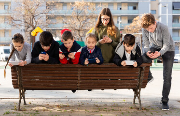 Children are playing on smartphone in the playground. High quality photo
