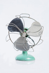 Old, battered and bent but this rustic antique electric fan still works. White background with copy space.