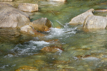 Naklejka na ściany i meble Mountain stream flowing between rough river rocks on a diagonal path in the Washington Cascades