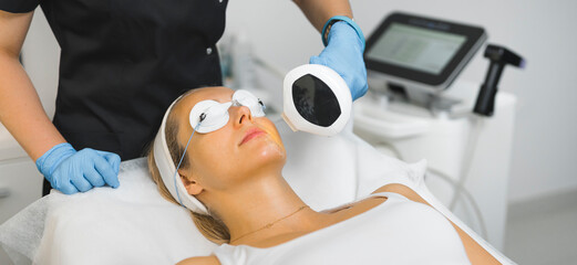 young pretty woman having nonsurgical face lifting procedure at the salon, facial and beauty...