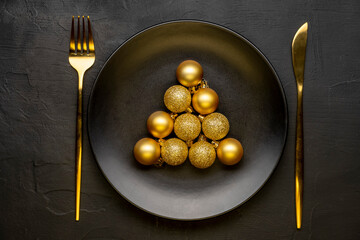 Golden Christmas table. Plate with Christmas decorations on black background. Happy new year.
