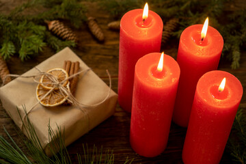 Four red candles with Christmas decoration background