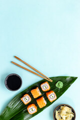 Sushi roll set with chopsticks on green Bamboo leave, top view