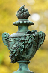 antique funeral urn at a historic cemetery against blurred autumn colors