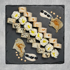 Obraz na płótnie Canvas beautifully laid out sushi set on a blackboard