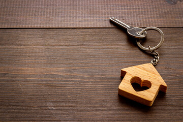 Fototapeta na wymiar Wooden house shaped keychain with keys. Real estate concept