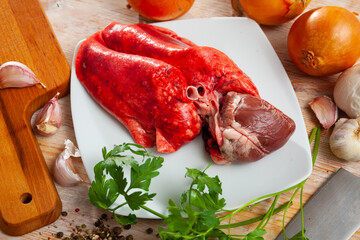Image of raw lamb lungs and heart served with greens during cooking