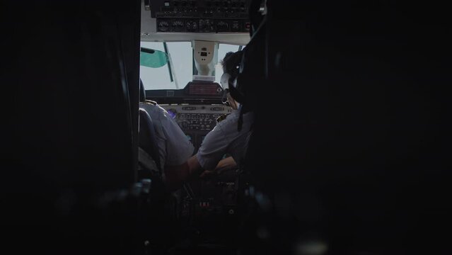 Two male pilots in cockpit flying airplane