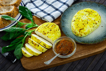 Sliced appetizing fried flavorful cottage cheese seasoned with cumin seeds and turmeric on wooden...