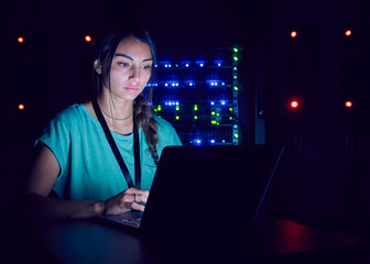Technician using laptop in server room