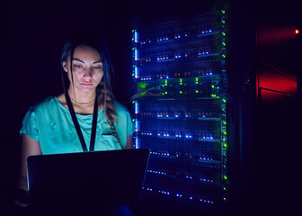 Technician using laptop in server room