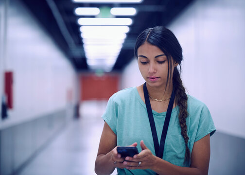 Female technician looking at smart phone in data center