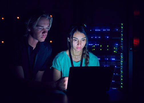 Technicians using laptop in server room