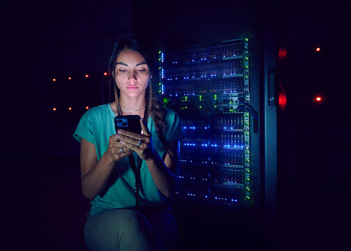 Technician using smart phone in server room