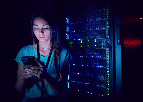 Technician using smart phone in server room