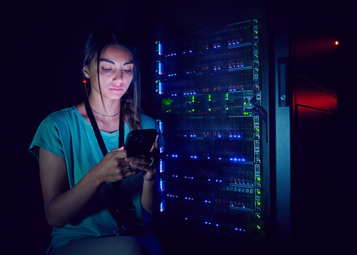 Technician using smart phone in server room
