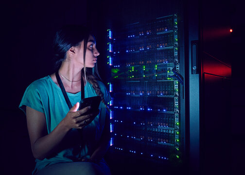 Technician with smart phone in server room