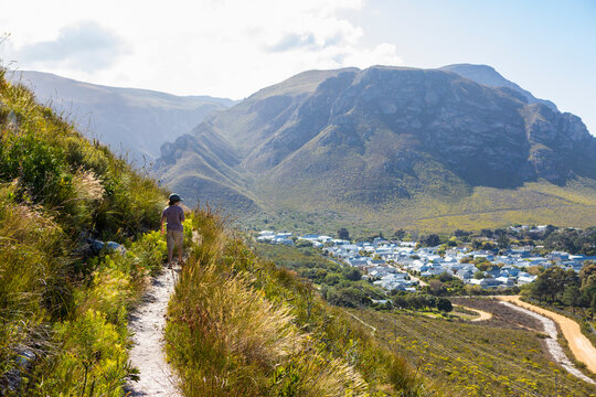 South Africa, Hermanus, Boy (8-9) looking at small town from hiking trail in mountains