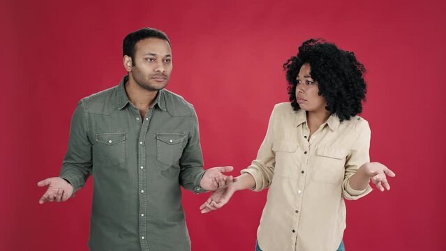 Man and African American woman spread hands in confusion
