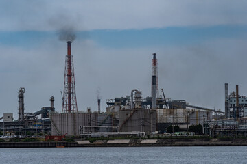 Smoke is coming out of factories chimney near the sea in Kitakyushu city Japan.