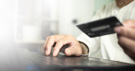 person typing on  laptop and holding credit card, online shopping with credit card