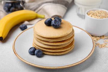 Tasty oatmeal pancakes on grey table, closeup