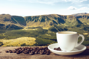 Cup of aromatic hot coffee on wooden table and beautiful view of mountain landscape. Space for text