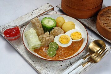 Siomay or Somai,Indonesian steamed fish dumpling with vegetables served in peanut sauce.	