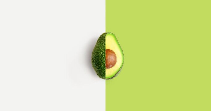 Creative animation made of avocado full an peeled on the white and green background. Animation concept food. 