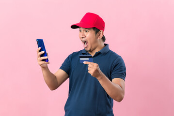 Shocked Young Asian man in casual t-shirt with a hat holding mobile phone and credit card