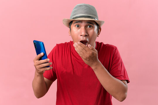 Close-Up of shocked Asian man using mobile phone