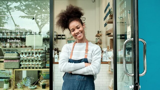 Young African American Female Shopkeeper Opening Glass Door, Happy Smile, Works At Refill Store, Zero Waste, Plastic-free Grocery Shop, Eco-friendly SME. Thai Language On A Label At Door Means-pull.