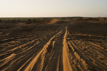 Car tyre marks on sand dunes of Thar desert, Rajasthan, India. Tourists arrive on cars to watch sun rise at desert , a very popular activity amongst travellers.