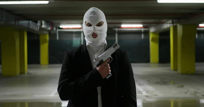 Man in a Suit with a White Mask Holding a Fun Criminal