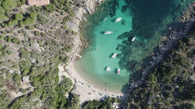 Tizzano Beach cove in Southwest Corsica Island France Mediterranean Sea with boats and bathing tourists, Aerial top view pan up shot