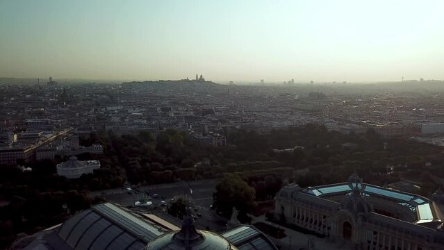 Aerial Tour of tourist attraction Paris city at sunrise with beautiful reflective sun flare on glassy rooftop of Grand Palais and Petit Palais