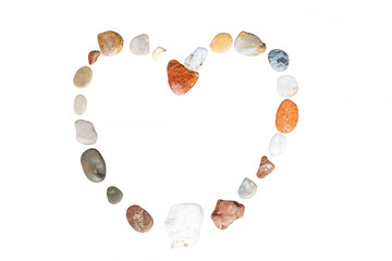 Multi-colored stones laid out in the shape of a heart on the isolated on white background. Romance and relaxation. Close-up.