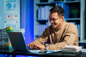 Overtime work concept, Handsome asian business man working late at night in office workplace.
