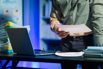 Overtime work concept, Handsome asian business man working late at night in office workplace.