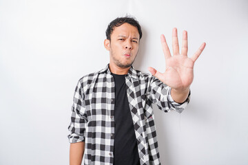 Handsome Asian man with hand gesture pose rejection or prohibition with copy space