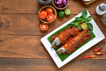 Balado ikan pindang salem, salted fish cooked with chilli sauce. Home cooking that has a distinctive taste, a blend of savory, salty and spicy. Served on plate with ingredients chili, tomato, spices