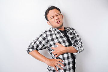 Tired upset young man suffering from back pain, muscle spasm at workplace. Fatigue, deadline, pain...