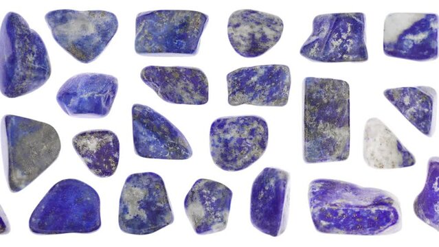 Lapis lazuli jewel stones set texture on light white isolated background. Macro closeup. Moving right seamless loop backdrop.