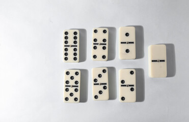 Domino pieces with white background, copy space and various agulos, concept of table games