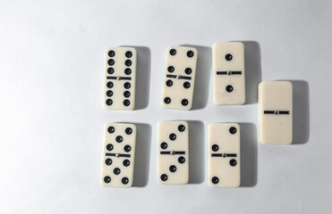Domino pieces with white background, copy space and various agulos, concept of table games