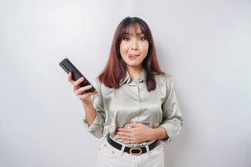 Photo of a hungry excited young woman holding her phone and wondering what to order yummy food...