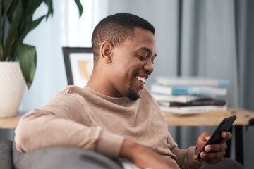 Happy black man, smartphone and relax in home, living room sofa and typing online, social media...